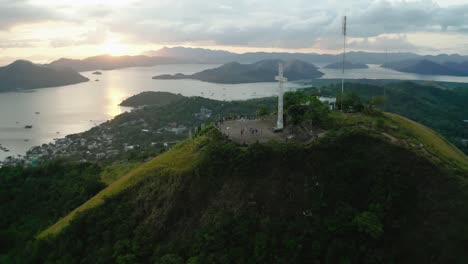 Vista-Aérea-De-La-Cruz-Blanca-En-El-Monte-Tapyas-Con-Cielos-De-Puesta-De-Sol-En-La-Distancia