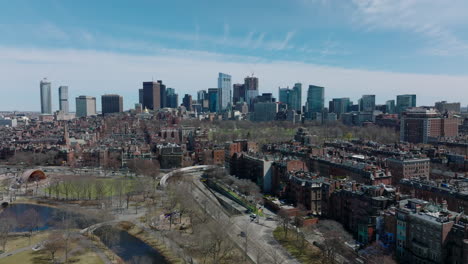 Aerial-panoramic-footage-of-metropolis,-classical-red-brick-apartment-houses-and-modern-downtown-skyscrapers-in-background.-Boston,-USA