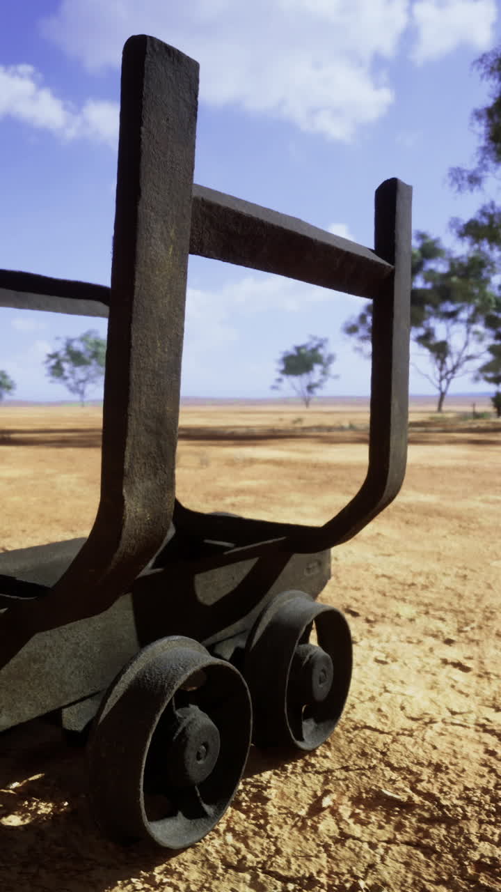 Forgotten cart stands alone in a desolate landscape under a bright sky