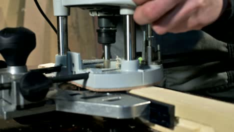 close-up of a carpenter's hand working with an manual electric cutter in a home workshop.