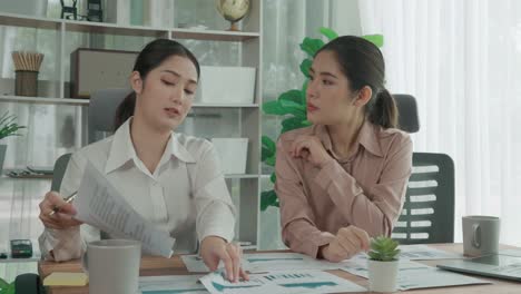 closeup-two-young-enthusiastic-businesswoman-work-in-office-with-report-paper.