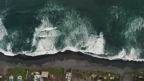 Vista-De-Arriba-Hacia-Abajo-De-Las-Espumosas-Olas-Del-Océano-Salpicando-La-Orilla-Arenosa-En-El-Paredón,-Guatemala---Disparo-De-Drones