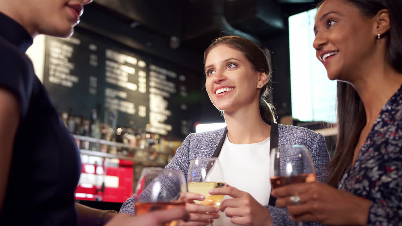 Group Of Female Friends Meeting For Drinks And Socializing In Bar After Work