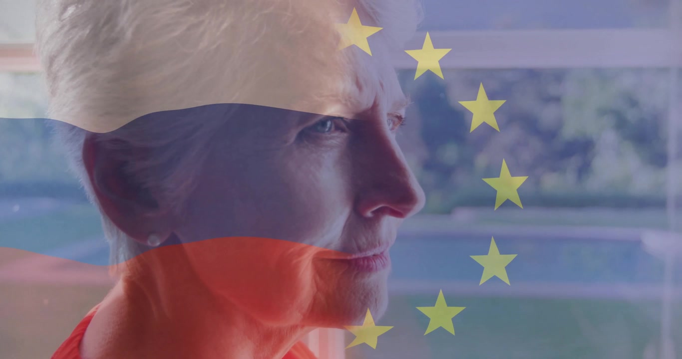Ældre kvinde står ved vinduet, et digitalt flag-overlay dukker frem, skiftende farvebånd hen over ansigtet