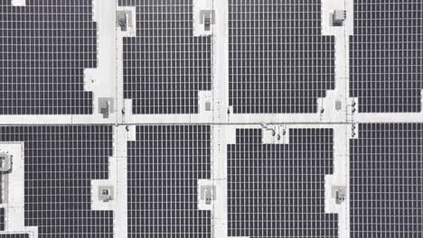 aérea de arriba hacia abajo de la granja de paneles solares instalados en el techo de la fábrica