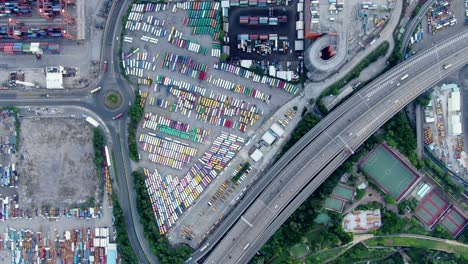 hong kong commercial port dock and holding platform with thous of shipping containers, aerial view