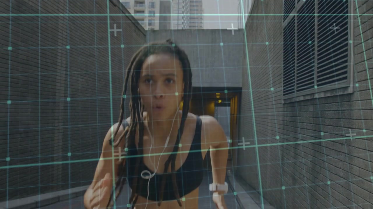 Woman inserting wired earphones, leaning and running toward camera, green AR grid tracking training