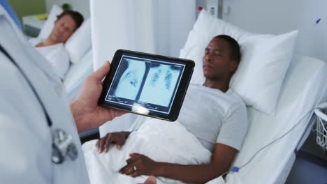 Nahaufnahme-Eines-Kaukasischen-Männlichen-Arztes,-Der-Sich-Den-Röntgenbericht-Auf-Einem-Digitalen-Tablet-Auf-Der-Station-Ansieht