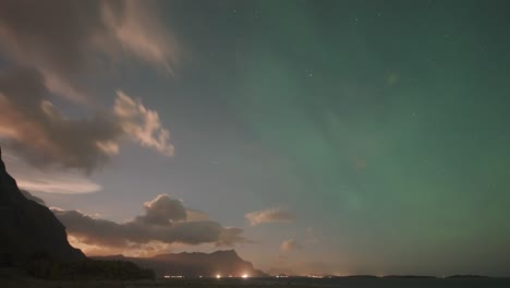 Der-Faszinierende-Tanz-Der-Aurora-Borealis,-Die-Die-Wolken-Vor-Dem-Hintergrund-Eines-Leuchtenden-Sonnenuntergangshimmels-Erleuchtet-Und-Ein-Atemberaubendes-Himmelsschauspiel-Schafft