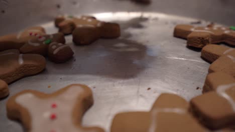 close-up sliding shot of gingerbread man cookies laying in a baking tray