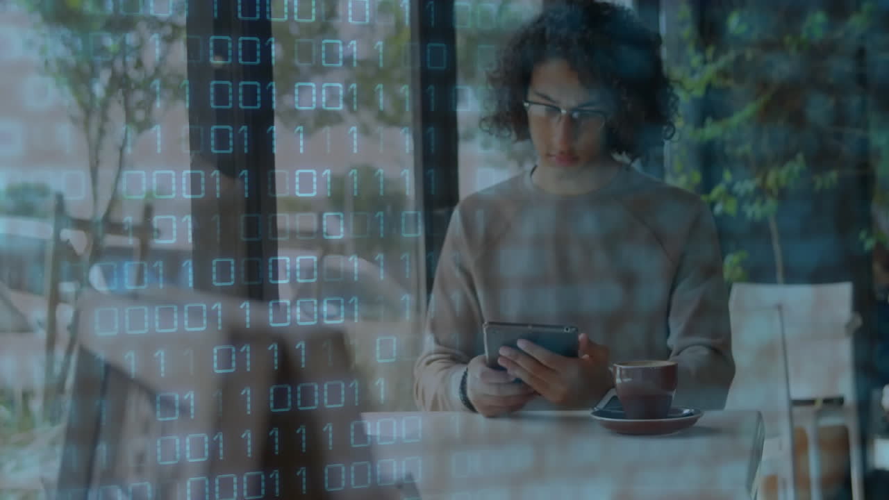 man using tablet while sipping coffee in cafe, glowing binary code overlay showing technology theme