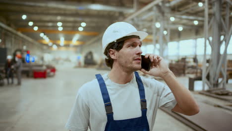 industrial machinery mechanic having phone talk during workday in factory