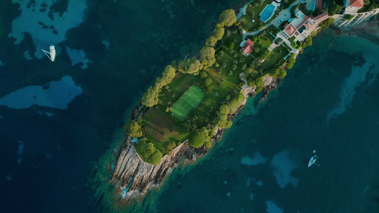 Aerial Top Down Orbital View Of Small Island With Luxury House and Tennis Court In Garden, Cap-Ferrat France, French Riviera
