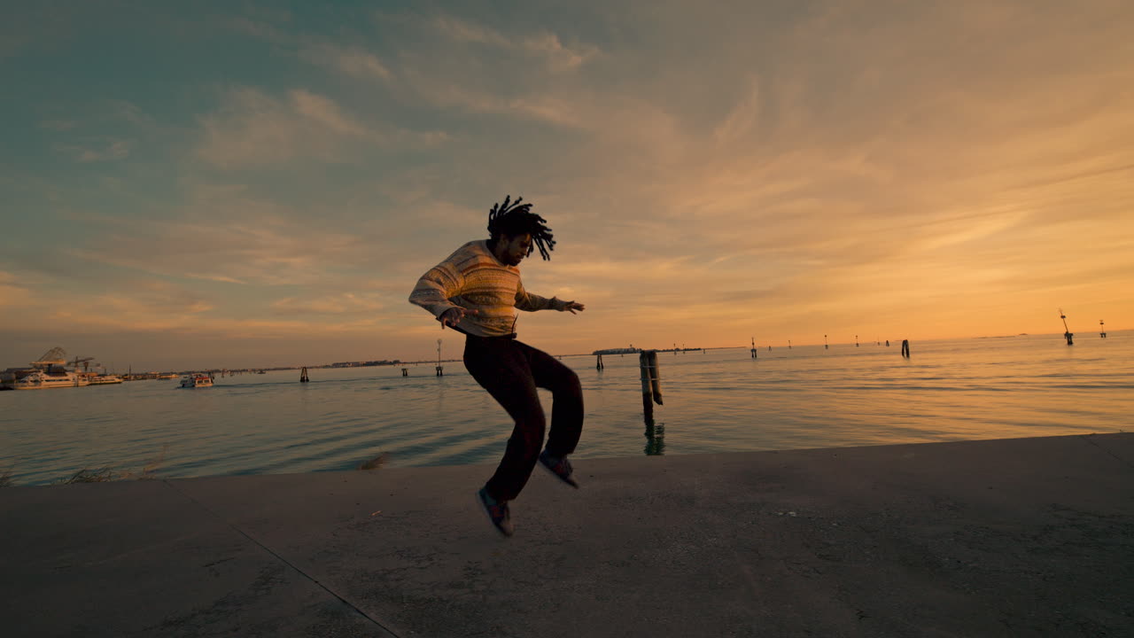 Danseforestilling ved vannet i solnedgang