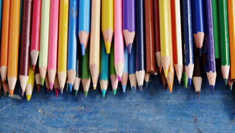 Various-color-pencils-arranged-on-wooden-table