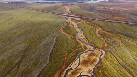 Meandering-river-through-iceland's-vibrant-landscapes,-shot-in-natural-light,-aerial-view