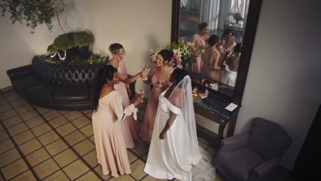 bride and bridesmaids celebrating with champagne before the wedding