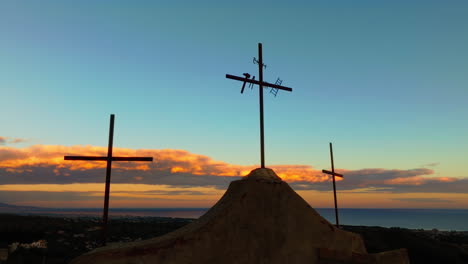 christian religious crosses on mountain as a symbol of god in the sunset sky