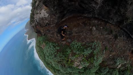 a fit and young man is hiking alone on the narrow path next to the steep edge in quebrada do negro in madeira