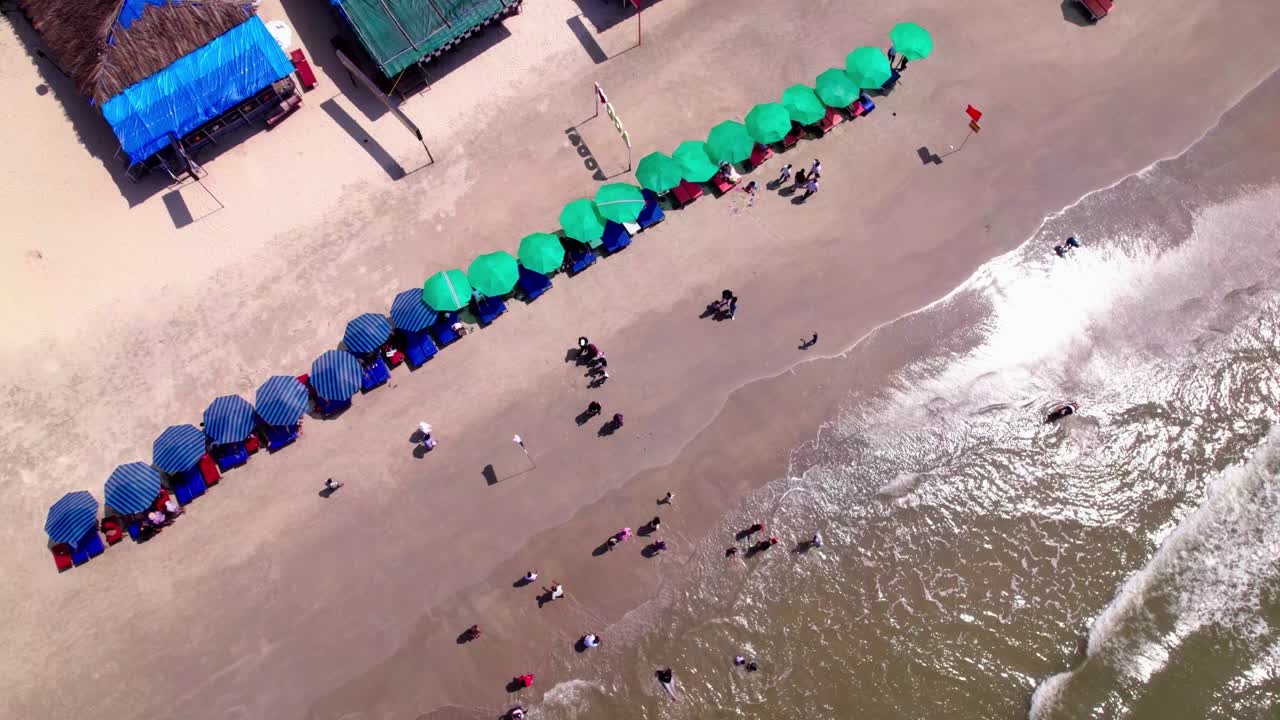 Beach shoreline with sunbeds and tourists. day time, top down shot, drone shot, 4k