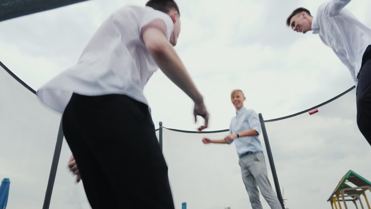 고등학교 졸업생 3명이 트램폴린에 뛰어든다