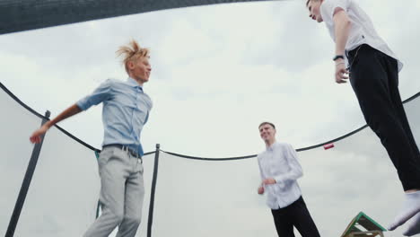 tres graduados de secundaria saltan en un trampolín