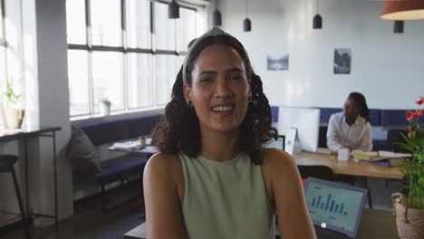 Portrait-of-happy-biracial-businesswoman-looking-at-camera-at-office