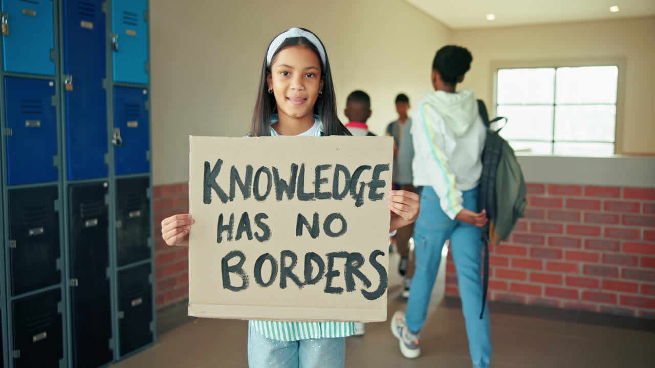 Student holding a sign that says 'Knowledge has no borders'