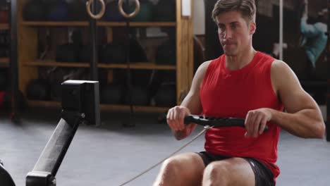 Front-view-athletic-Caucasian-man-exercising-on-a-rowing-machine