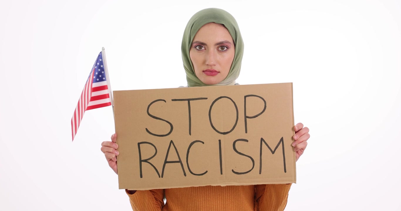 Woman holds cardboard sign with stop racism and american flag