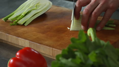 Chef-Cortando-Lentamente-Hinojo-En-Una-Tabla-De-Cortar-De-Madera,-Verduras