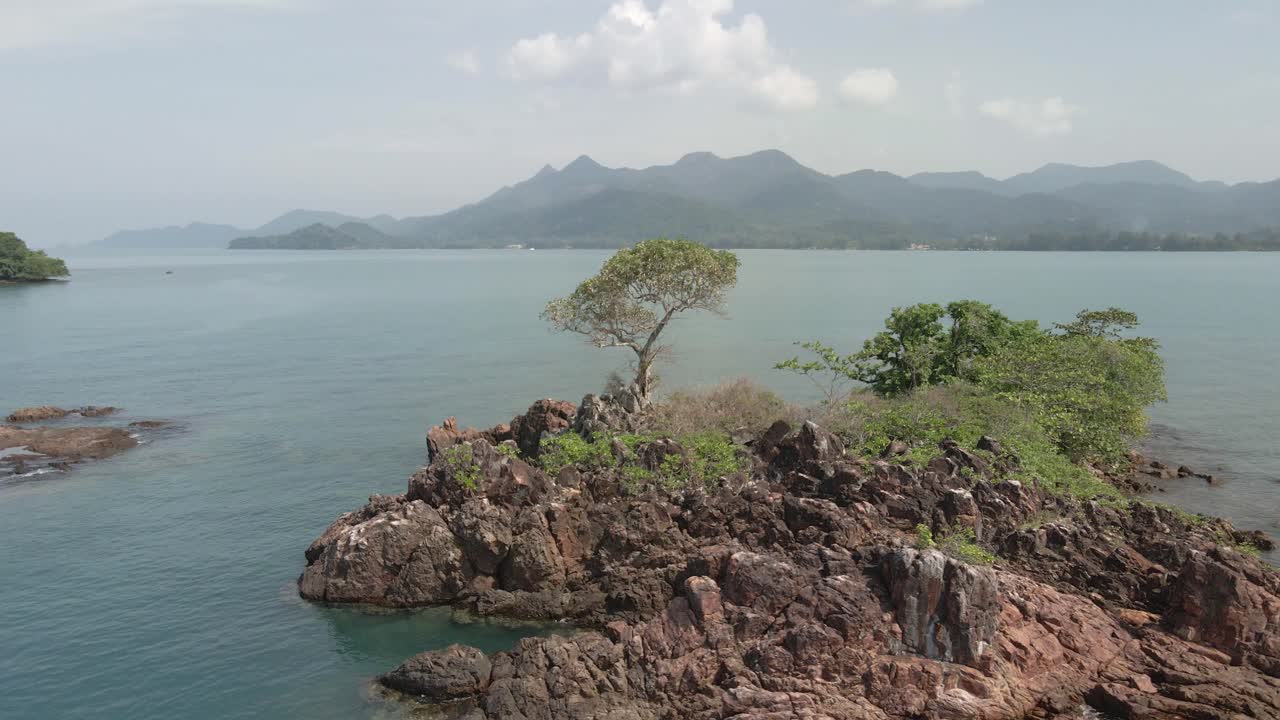 Aerial orbit small rocky tropical island in Thailand Koh Chang background