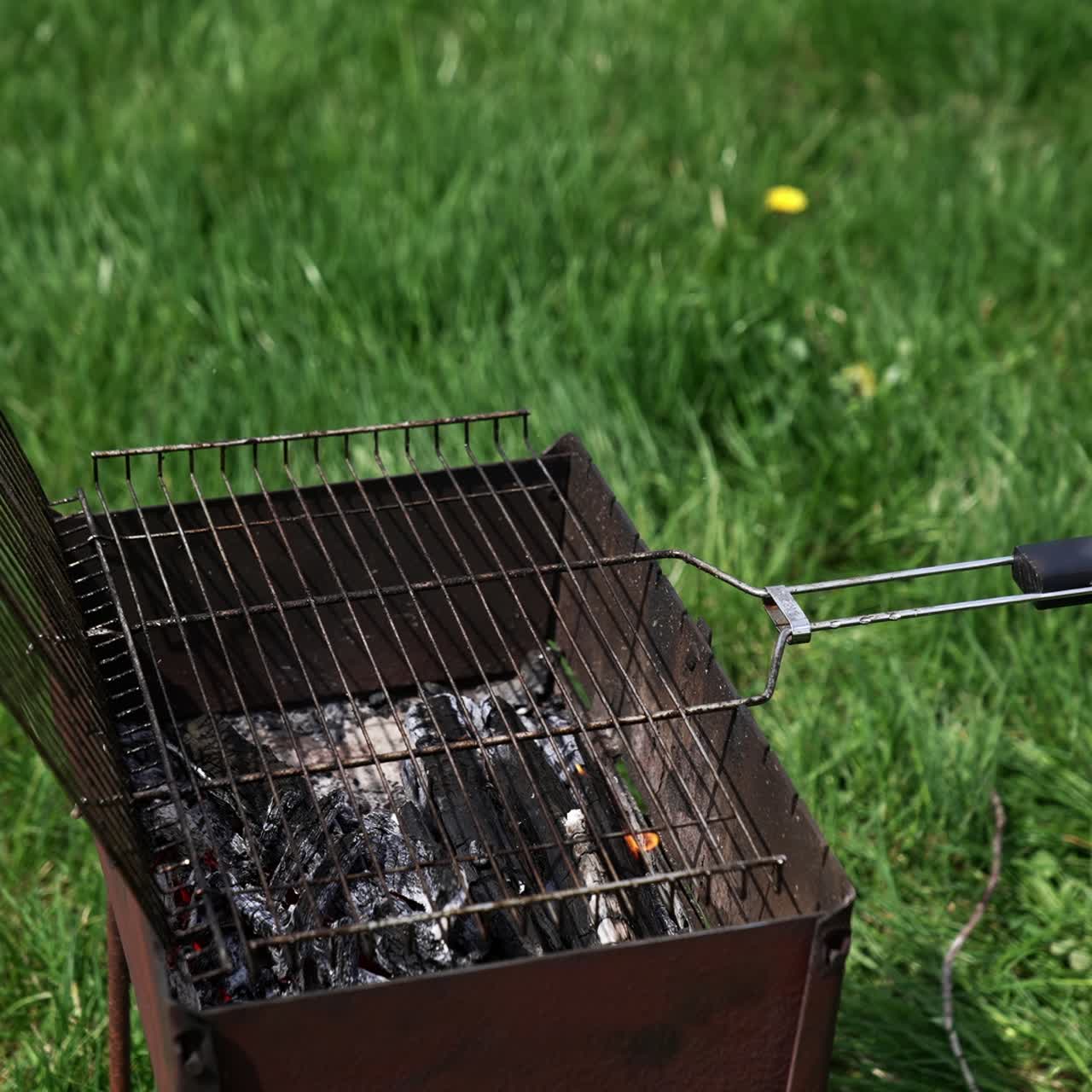 Brazier in nature at summer day. Charcoals in brazier for grilling food. Cooking barbeque on brazier. Prepare grilling charcoal heat for roasting meat. Concept of picnic with barbecue
