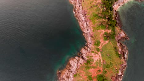 Overhead-drone-shot-over-a-the-ridge-of-a-peninsula-in-Laem-PhromThep-Cape,-located-in-the-island-of-Phuket-in-Thailand