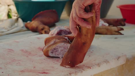 pig feet being chopped on table during traditional slaughter in minho portugal