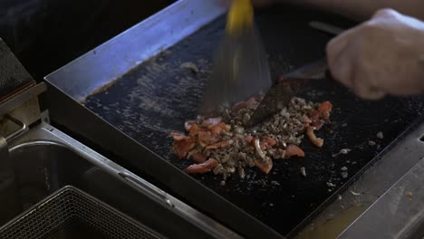 chef preparing hot philadelphia meat on hot grill in restaurant kitchen