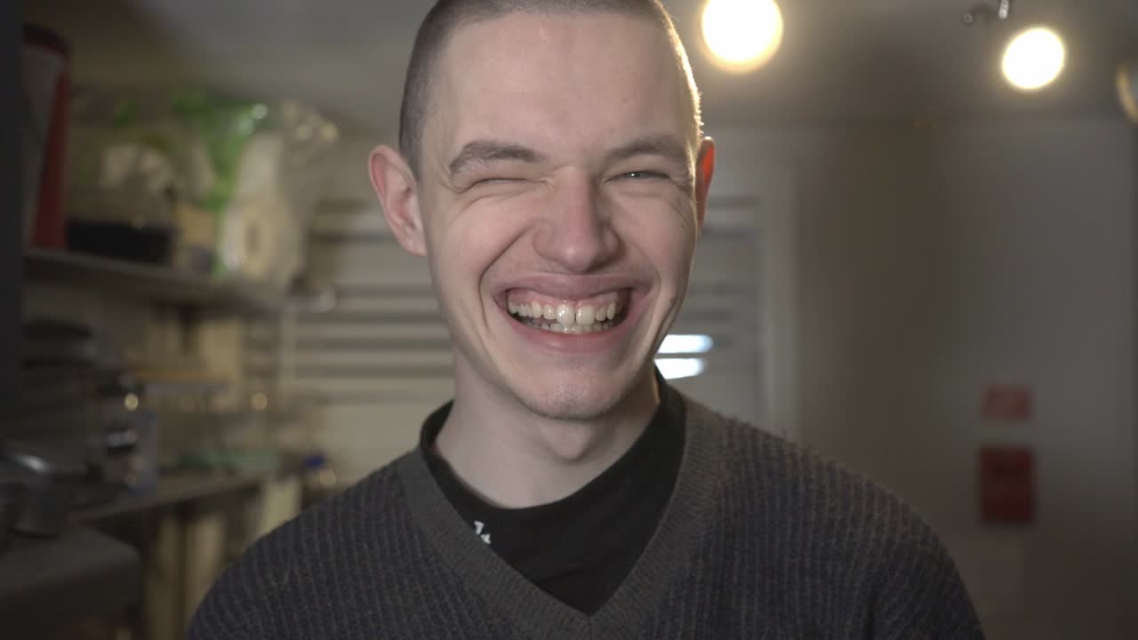 A White Adult Male With A Buzz Cut Laughing With His Mouth Open And Teeth Exposed. -medium shot