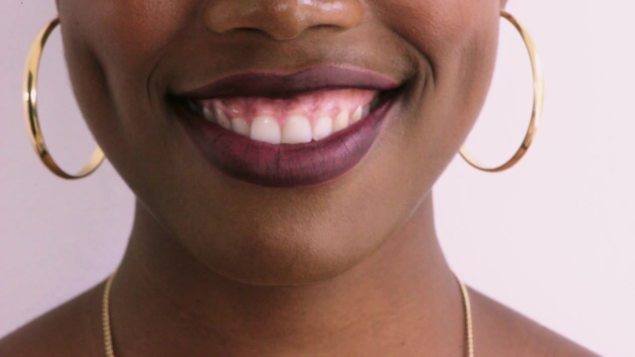 Close-up of a Young Woman Smiling with Dark Lipstick