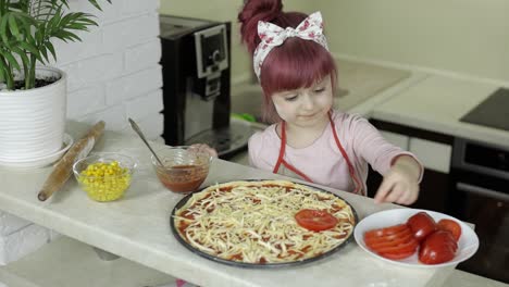 Pizza-Kochen.-Kleines-Kind-In-Schürze-Gibt-In-Der-Küche-Geschnittene-Tomaten-Zum-Teig