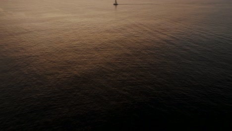 sailboat in the sea in the evening sunlight in guanacaste, costa rica - aerial drone shot