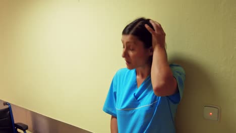 depressed nurse leaning in corridor