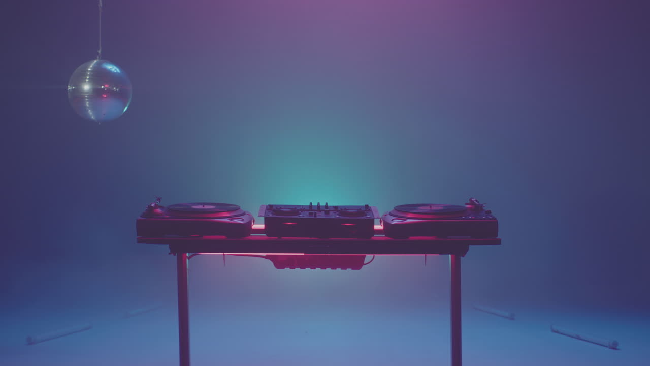 Postazione DJ con palla da discoteca e luci al neon