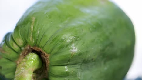 Un-Primerísimo-Plano-De-Papaya-Amarilla-Madura-Girando-Sobre-Una-Plataforma-Giratoria-Que-Muestra-Sus-Hermosas-Y-únicas-Manchas-Y-Piel