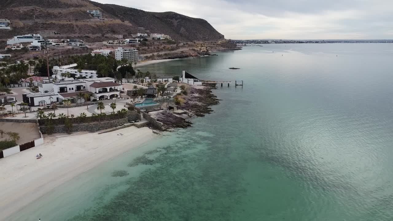 toma aérea ascendente de la maravillosa playa de playa el caymancito cerca de la paz baja california sur méxico con vistas al mar turquesa y los hermosos edificios durante unas grandes vacaciones