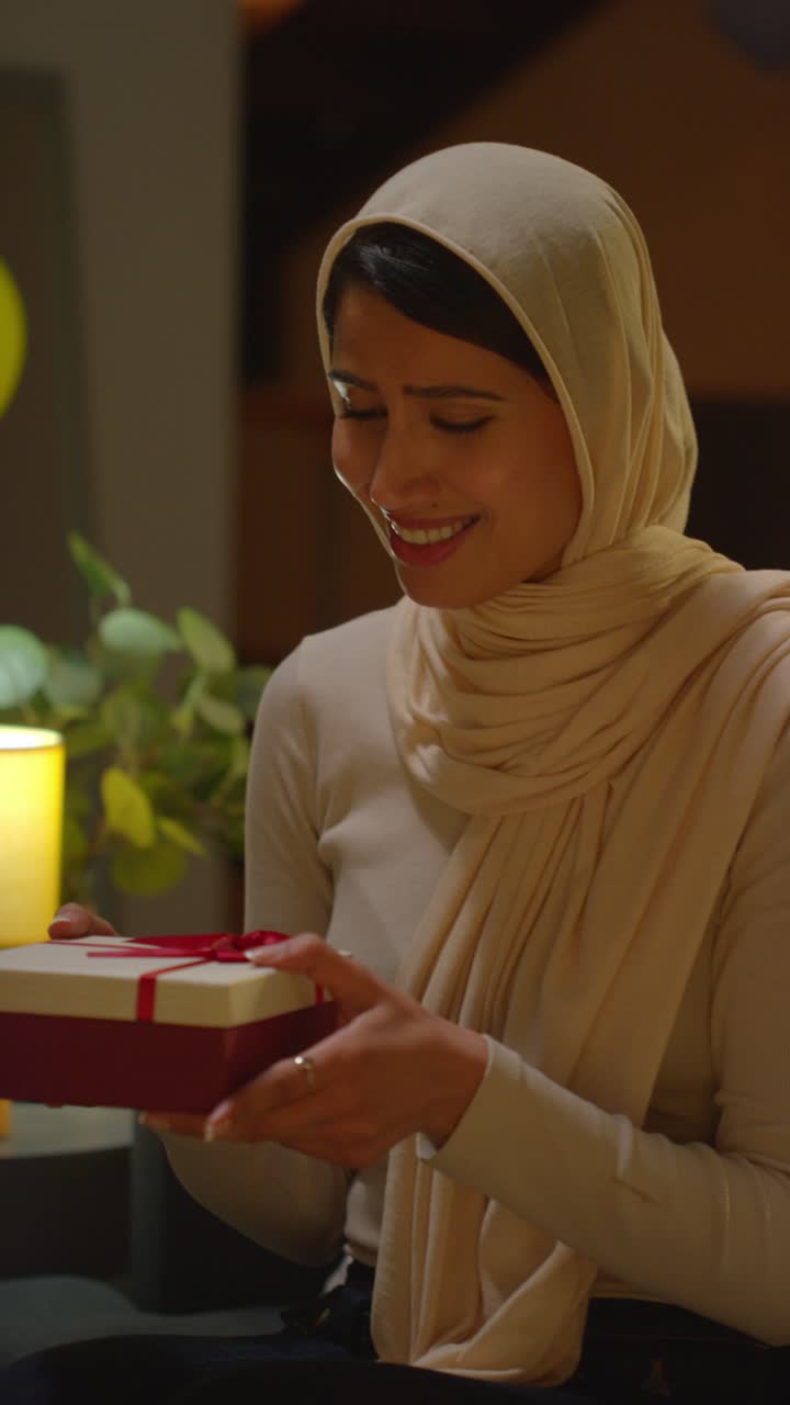 video vertical de una mujer dando un regalo de cumpleaños a una amiga en casa con globos de fiesta en el fondo 2