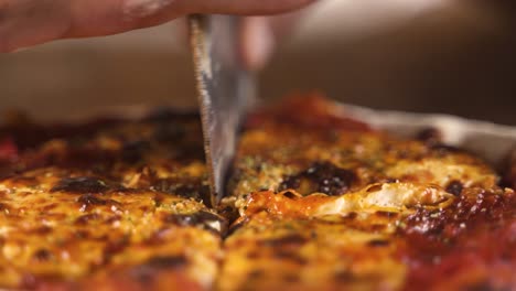 cortar con cuchillo deliciosa pizza casera ahumada caliente en mesa de madera cerrar cámara lenta 60fps