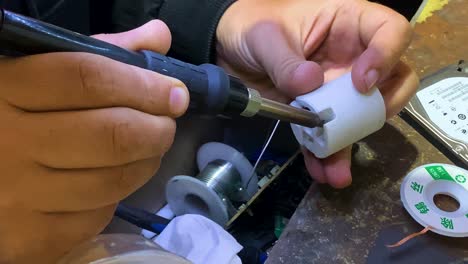 electrician soldering cable to the light bulb base