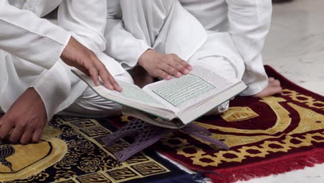 close up shot of muslim men reading quran holy book