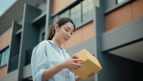 beautiful young woman receiving parcel from blue uniform delivery man f the house with good service from shopping online. courier man delivering a cardboard box postal package to destination.