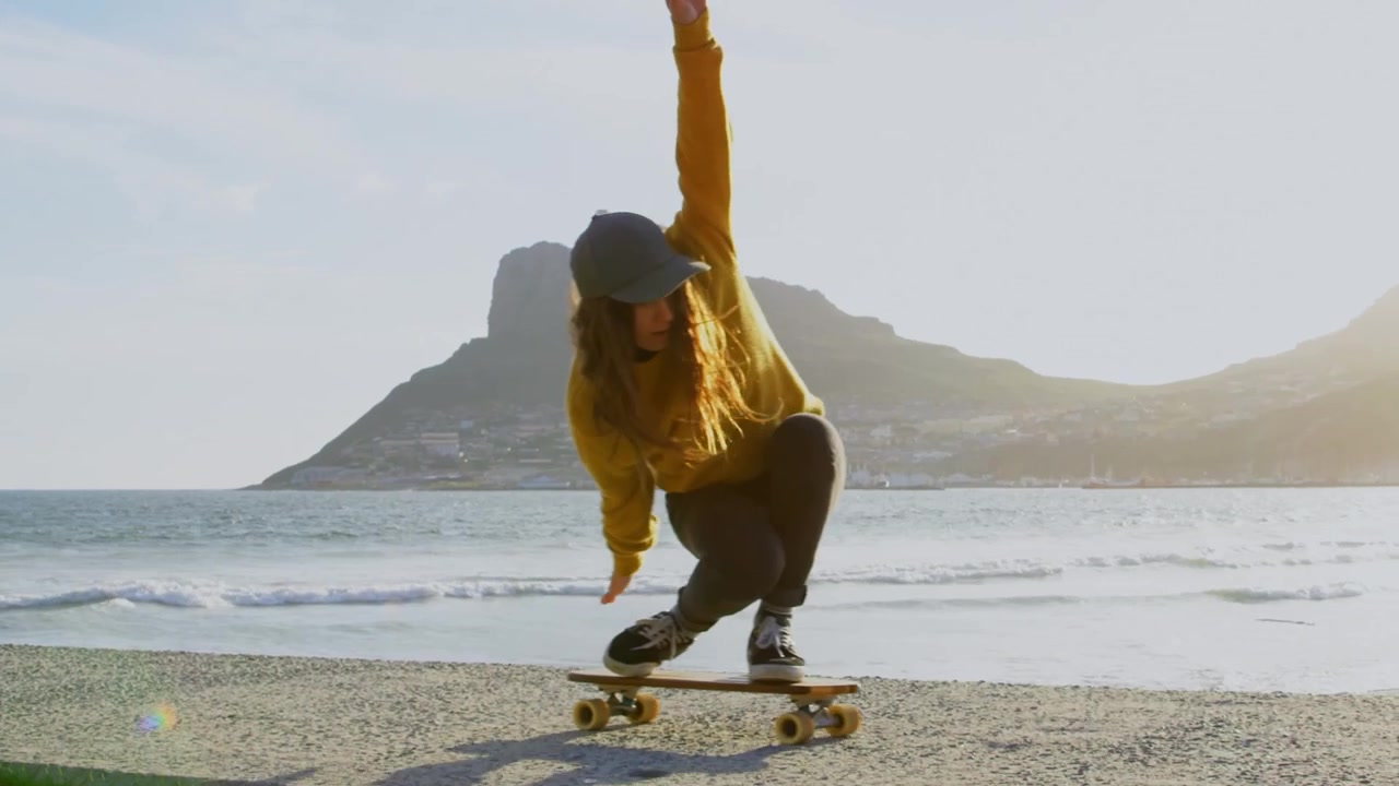 Vänner som åker skateboard och surfar på stranden